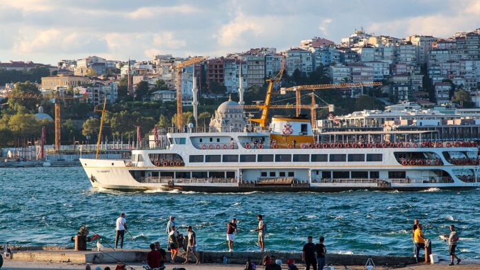 A ferry crosses the Bosphorus in front of Istanbul's waterfront.